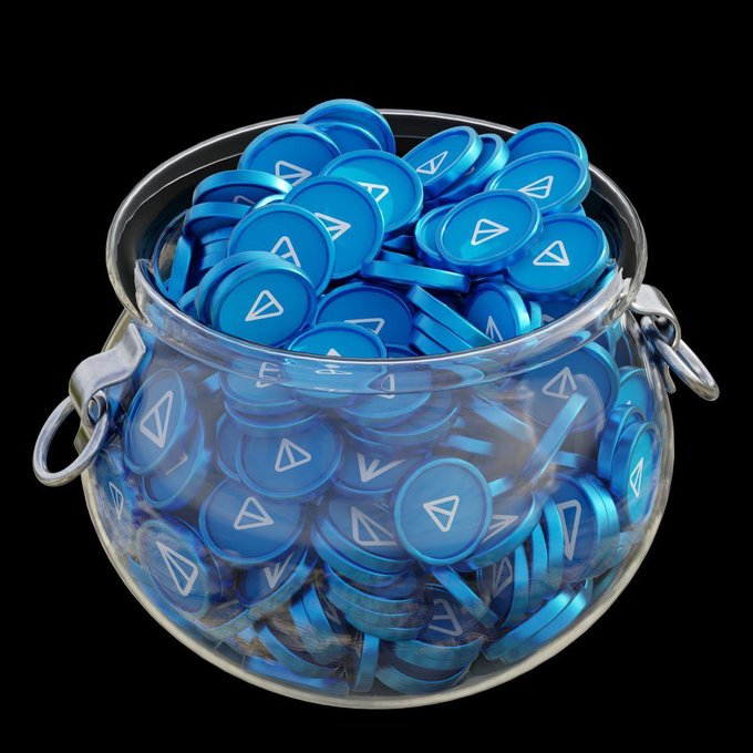 The image features a glass jar filled with blue coins, which are likely babyton's new mini-app currency. The jar contains approximately 100 coins, each adorned with a white triangle symbol. The jar is placed against a black background, making the blue coins stand out prominently. The caption of the post reads "Something is coming... Babyton's new mini-app will be launched in the next few days with the ability to predict World Cup matches". This suggests that the image is related to the release or launch of babyton's mini-app and its potential use for predicting sports events, such as the World Cup.