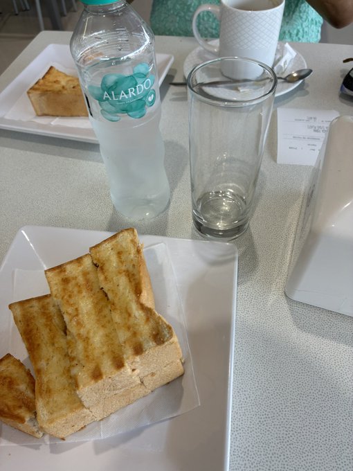 The image shows a dining table with two plates of toast, a glass of water, and a coffee cup. There are also utensils like a fork and spoon placed on the table. The scene appears to be set for breakfast or brunch, as there is a person visible in the background who seems to be enjoying their meal. The post about the hyperliquid has been shared by someone named "gm crypto" on Twitter, possibly indicating that they found it interesting or entertaining.