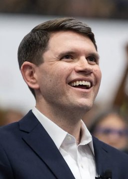 James Talarico smiles broadly while wearing a dark suit jacket and white shirt, appearing in what looks like a public or campaign setting. The image relates to the post by showing the Democratic candidate whose chances of winning a U.S. Senate seat in Texas have surged to 52% on Polymarket, despite the state not electing a Democrat to that office since 1988.
