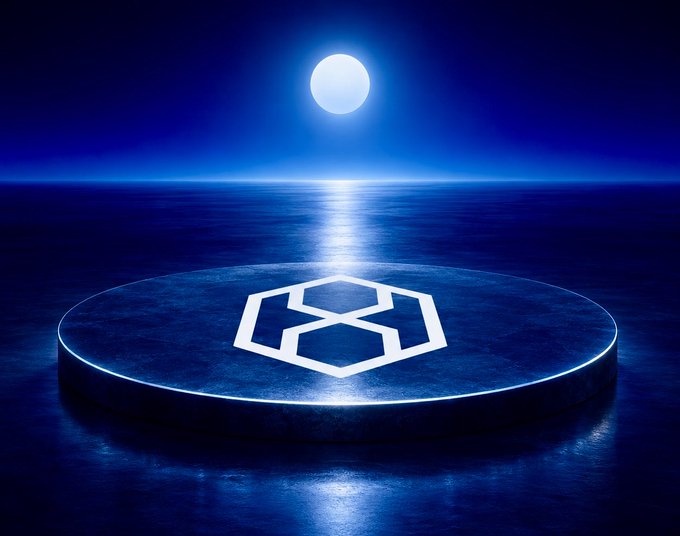 A dark blue digital artwork showing a glowing geometric cube logo on a circular platform reflected over water, with a full moon illuminating the scene above the horizon.