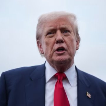 President Donald Trump, wearing a dark suit with a red tie, is shown speaking outdoors against an overcast sky. The image accompanies news of an upcoming gala at Trump National in Washington for top $TRUMP token holders.