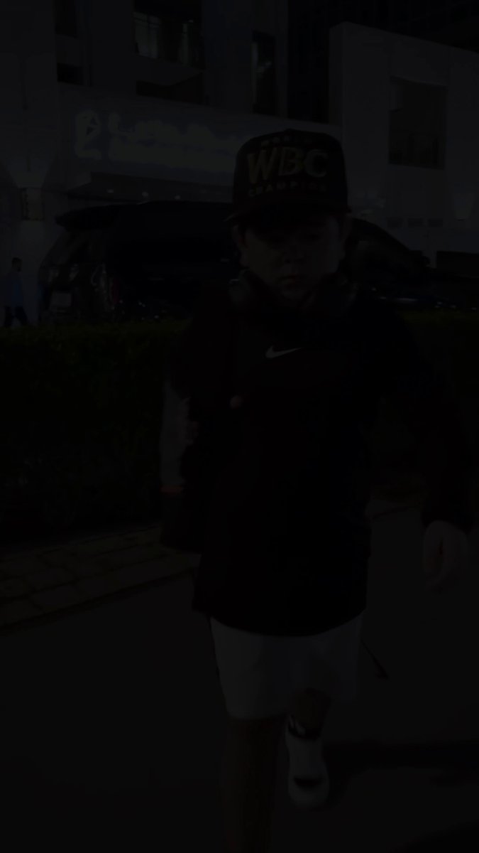 The image features a young boy wearing a baseball cap and shorts walking down a street at night. The caption of the image includes information about a team called @Shadowcleague, which has been working hard since launch to push forward their project across crypto. They are collaborating with another team, @rozikrypto, to expand their reach and share their knowledge with more people.