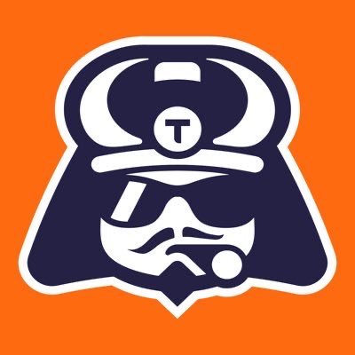A stylized logo featuring a bearded figure wearing a horned helmet with a "T" emblem on the forehead, set against an orange background. The image visually represents the "God's chosen one" described in the post, serving as the mascot for ToshiBet, a crypto casino brand.