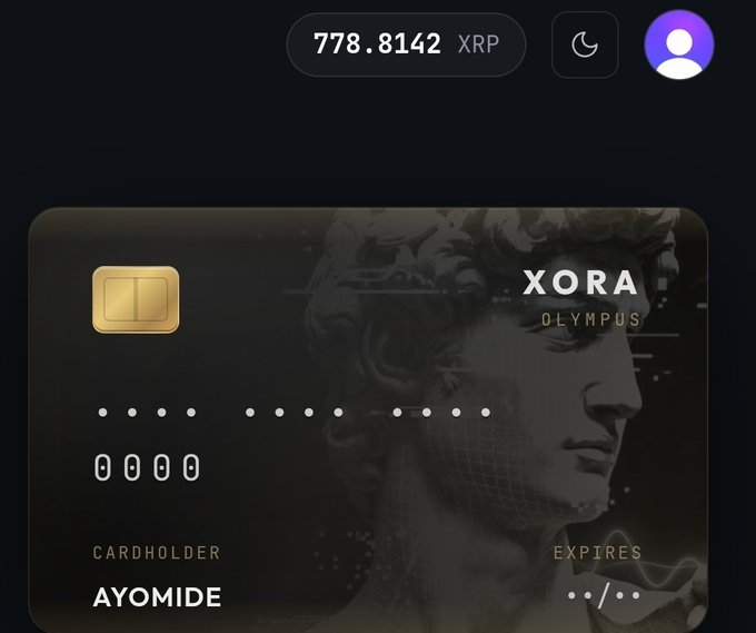 A sleek digital banking interface displays an account balance of 778.8142 XRP at the top alongside a profile icon and dark mode toggle. Below, a premium black Xora Olympus card is shown featuring a classical statue watermark, with cardholder name "AYOMIDE" and masked card details, visually showcasing the neobank's branded card product for XRP holders.
