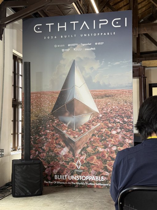 The image shows a large promotional banner for "ETHTAIPEI 2026 BUILT UNSTOPPABLE," featuring the Ethereum logo atop a field of pink roses, with sponsors like BSOS, Signmarket, and Coinbase listed. The accompanying post expresses joy at seeing an old friend from EthTaipei, suggesting the photo captures the welcoming entrance or event setup of the 2026 Ethereum conference, where the speaker is encountering familiar community members.