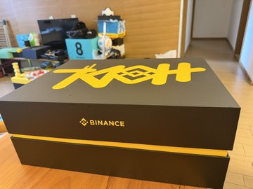 A black Binance-branded shipping box with yellow '大风口H' text sitting in what appears to be an indoor residential space.