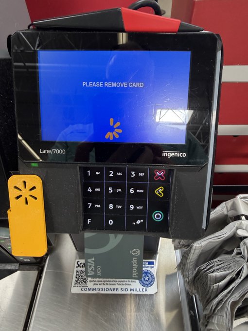 A close-up of a Walmart self-checkout payment terminal (Ingenico Lane/7000) displaying "PLEASE REMOVE CARD" on its blue screen, with a Visa credit sticker below from "Commissioner Sid Miller." The image complements the post by showing a credit/debit card transaction terminal, reinforcing the theme of everyday payment and financial transactions tied to the @upholdinc platform and XRP.