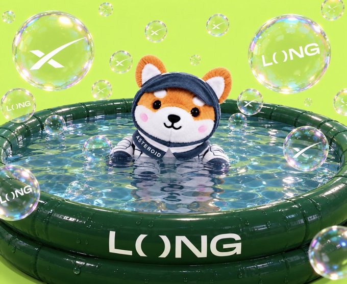 An ASTEROID plush bear mascot in an astronaut suit sits in a green inflatable pool branded "LONG" surrounded by bubbles against a green background.
