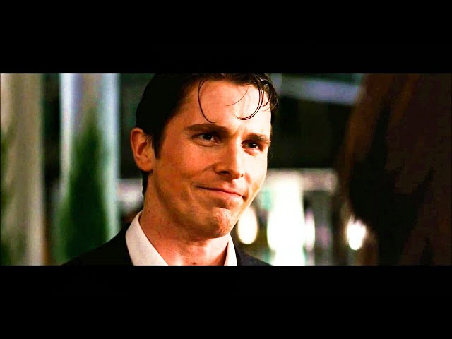 A man in a suit with wet-looking hair smiles subtly in what appears to be a film still, likely from the movie Bruce Almighty featuring Jim Carrey.