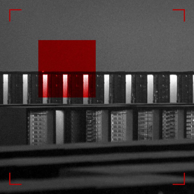 A close-up, black-and-white image of a barcode with a red square highlighting a section of it, framed by red corner markers.