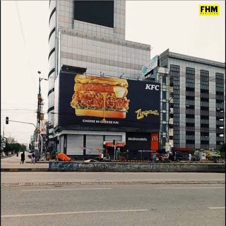 A large KFC billboard advertises their "Cheese & Cheese Ham" sandwich against an urban backdrop featuring a McDonald's sign and other buildings. The "copy paste" post suggests the image was used in a context where the billboard's placement or content was duplicated or shared online without attribution.