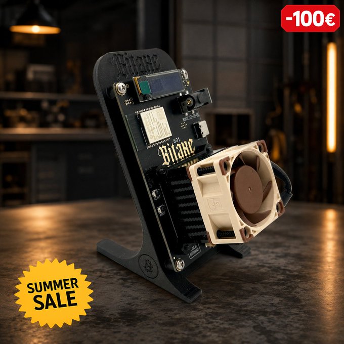 A product photo of a 'Bitaxe' Bitcoin mining device on a black stand featuring a fan and circuit board, displayed in a workshop setting with a 'SUMMER SALE' badge and '-100€' discount tag.