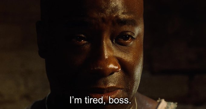 A close-up of a somber man's face with the subtitle "I'm tired, boss," conveying exhaustion and defeat that mirrors the crypto market's sharp downturn after US-Iran strikes wiped out $100 million in liquidations.