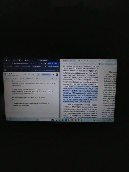 A dimly lit photograph shows two open browser windows side by side on a dark screen, displaying Portuguese text about electronic devices and pedagogical practices.