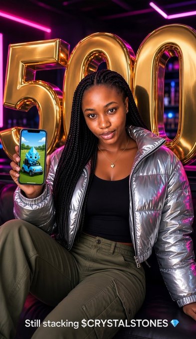 A young woman in a metallic silver puffer jacket poses in front of large golden "500" balloons, holding up her phone displaying an image of a small blue creature. The post's caption "Still stacking $CRYSTALSTONES 💎" appears at the bottom, tying together the celebratory 500 milestone aesthetic with the post's narrative about discovering the @crystalstones01 project focused on real-world mineral assets like gold and lithium.