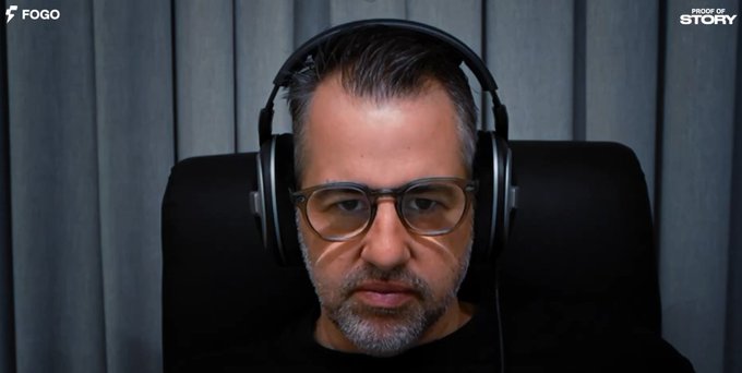 A man with glasses and headphones sits in a chair against a gray background, with 'FOGO' and 'PROOF OF STORY' logos in the corners.