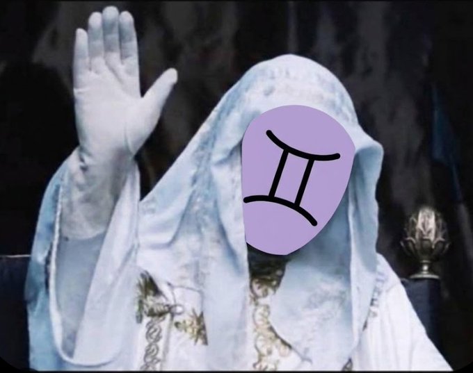 An image of a figure wearing a white hooded robe with one hand raised, but the face has been edited/covered with a purple shape displaying the Gemini zodiac symbol.