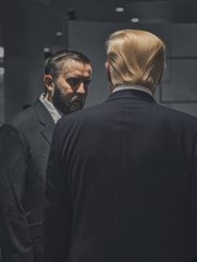 A bearded man in a suit stares intensely at a blonde-haired man seen from behind in a sleek, modern setting. The image evokes a confrontational or pivotal exchange, symbolizing the $LINK community's evolution and refusal to back down despite challenges.