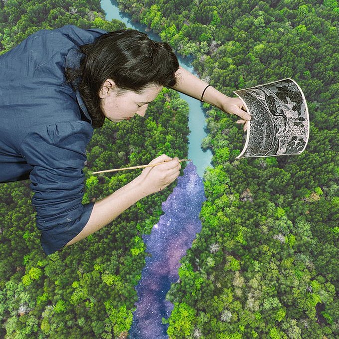 A surreal composite image showing a giant woman lying over a green forest landscape, painting a river purple and blue while holding a black-and-white reference drawing.