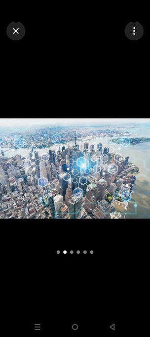 The image shows an aerial view of a city skyline overlaid with glowing digital hexagonal patterns, symbolizing blockchain technology and connectivity. It visually represents the decentralized network concept referenced in the post about building the crypto community one block at a time.