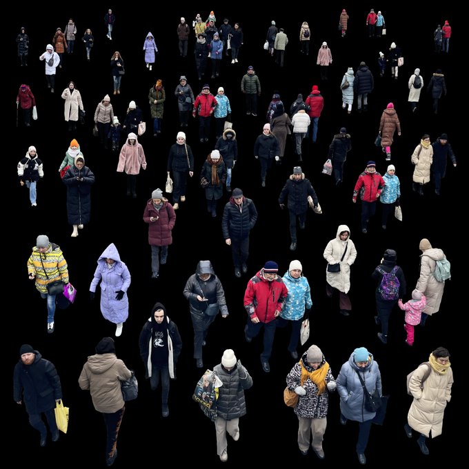 An overhead view of many people dressed in winter coats and jackets walking against a black background.