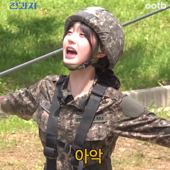 A young woman in Korean military camouflage uniform and helmet screams upward with arms outstretched on what appears to be an obstacle course. Korean text "전공지" appears top-left, "ootb" top-right, and "야악" (yaak/ugh) is captioned at the bottom, humorously expressing the same frustrated exasperation as the post's complaint about the absurd "94 mini figures just for Brave" registration requirement.