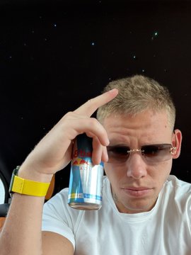 A man wearing sunglasses holds up a Red Bull can while posing against a starry space-themed backdrop, channeling a "Good morning... to the stars" vibe with his "Gm" greeting.