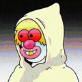 A small image showing a hooded character with a red mask and yellow eyes against a dark background.