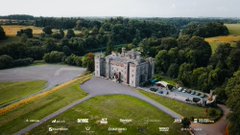 An aerial view of a castle-like building surrounded by lush green countryside.