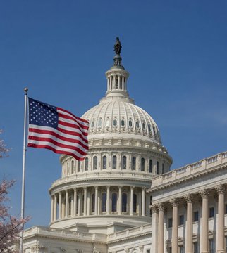 The image shows the U.S. Capitol dome with the Statue of Freedom on top, alongside an American flag waving in the foreground against a clear blue sky.

The image visually reinforces the post's message by symbolizing the U.S. legislative process, as the Capitol represents the very venue where the Senate's return and the potential passage of the CLARITY Act would take place, directly tying the location of governmental decision-making to the upcoming crypto regulatory catalyst.