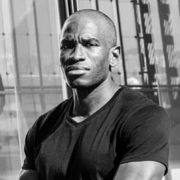 A black-and-white portrait shows a man in a dark V-neck t-shirt posing confidently in front of a modern glass building, likely representing Arthur Hayes, the BitMEX co-founder, in a visual accompanying his bullish crypto market commentary.