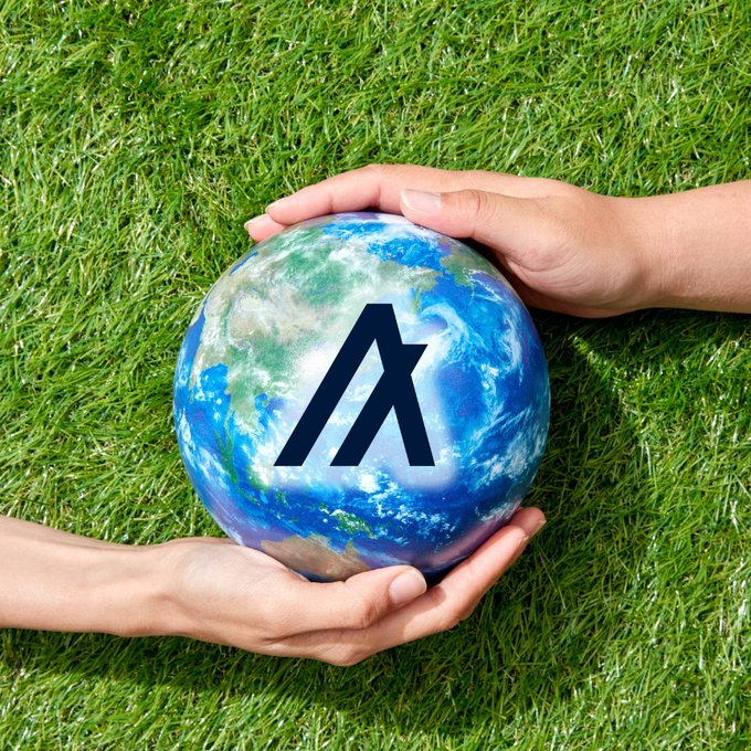 Two hands gently cradle a globe of the Earth against a grassy background, with the Algorand (ALGO) logo prominently displayed in the center of the planet—symbolizing how the inclusive, accessible blockchain is held up and protected by its community of everyday users, not just large stakeholders.