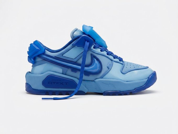 A blue monochromatic Nike sneaker designed to look like a PlayStation controller, featuring 'RTKT' on the side.