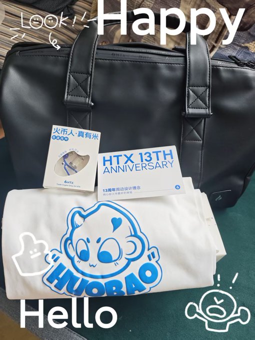 A black briefcase displayed behind merchandise including a white t-shirt with a blue cartoon monkey logo and 'HUORAO', alongside a tag reading 'HTX 13TH ANNIVERSARY', with 'Happy', 'Look!', and 'Hello' text overlays.