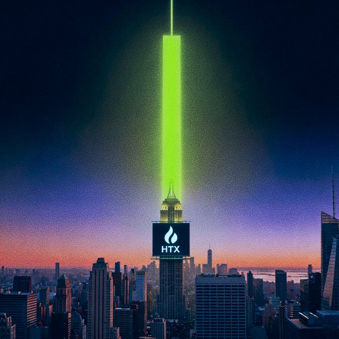 A towering green laser beam shoots up from the Empire State Building into the twilight sky above the Manhattan skyline, with the "HTX" logo displayed on the building's facade. The vibrant green illumination serves as a visual pun on the post's "touch of green" message, a bullish market signal indicating gains to start the trading week.