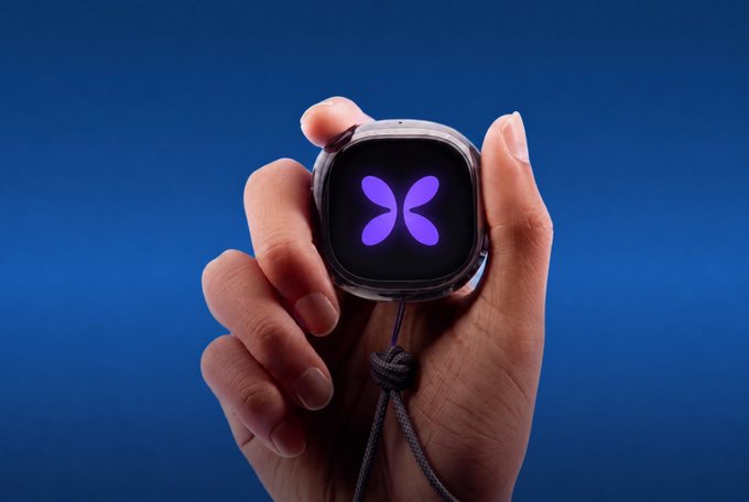 A hand holds a small square smartwatch displaying a glowing purple butterfly logo against a deep blue background.