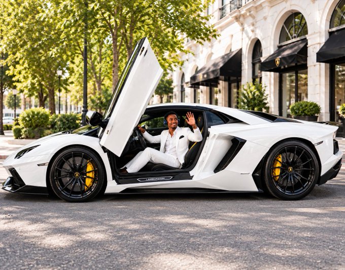 A man in a white suit sits in a white Lamborghini Aventador with scissor doors open, parked on a street lined with trees and upscale buildings.