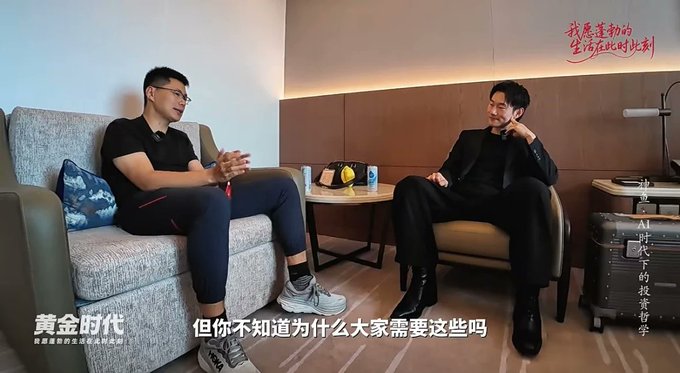 Two men sit in armchairs during an interview, with the subtitle “但你不知道为什么大家需要这些吗” and the show title “黄金时代” visible; the post links the conversation to Shen Yu discussing AI, entrepreneurship, investing, and his asset-allocation approach.