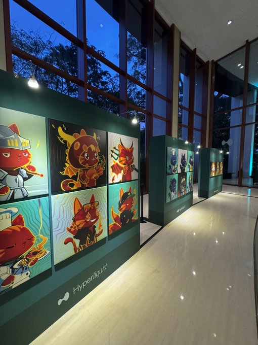 An indoor exhibition displays a gallery of vibrant cartoon character artwork, including knight, dragon, and fox-themed illustrations, with the "Hyperliquid" branding visible at the base of the wall. The image ties to the post by capturing the atmosphere of a Hyperliquid-hosted trader event, where despite market fatigue, the message highlights Hyperliquid as the emerging hub for all of finance.