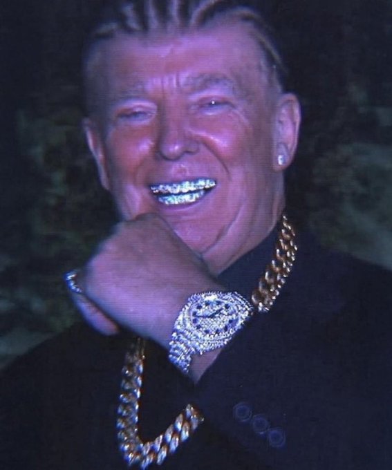A photo of a smiling man with braided hair wearing diamond-encrusted grills, a large diamond-studded watch, a diamond earring, and gold chains.