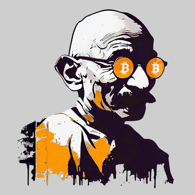 A stylized street art portrait of Mahatma Gandhi wearing sunglasses with orange lenses featuring the Bitcoin '₿' logo, with orange and black paint splatters.