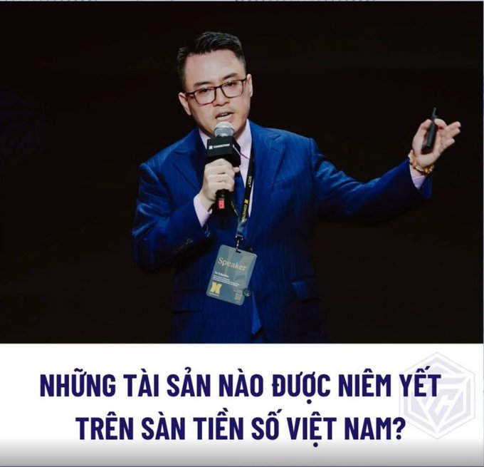 A man in a blue pinstripe suit with glasses speaks into a microphone while wearing a "Speaker" badge, with Vietnamese text below asking "NHỮNG TÀI SẢN NÀO ĐƯỢC NIÊM YẾT TRÊN SÀN TIỀN SỐ VIỆT NAM?" (What assets will be listed on Vietnam's crypto exchange?). The image relates to the post by visually introducing a speaker discussing the five asset groups (NFTs, tokenized goods, tokenized cash flows, tokenized real estate, and green products) expected to be traded on Vietnam's new crypto exchange under Decree 284.