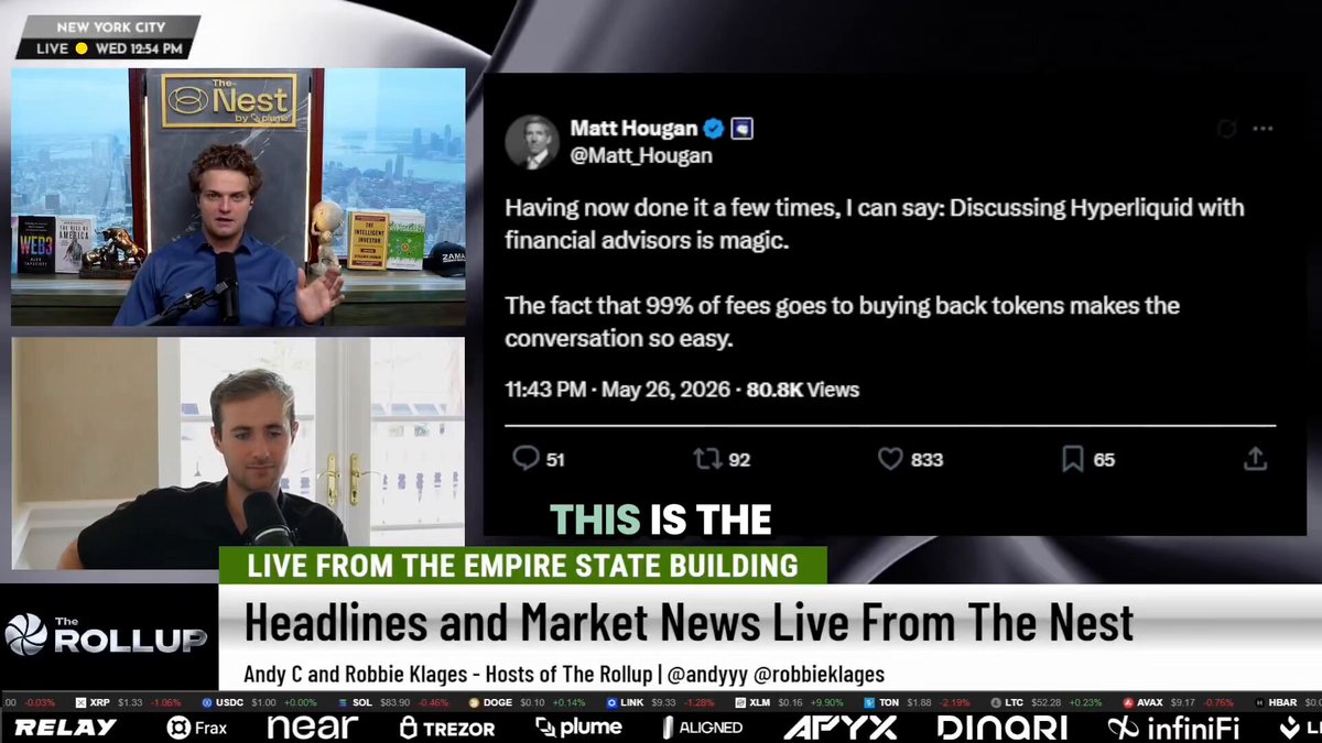 The image shows a news segment with two men talking about cryptocurrency, specifically Hyper Liquid and Bitwise. One man is holding up a gold coin while discussing their fundamentals. The other man is sitting at a desk, likely presenting information or data related to these companies. The background of the image features a cityscape, which could be an urban setting for the news segment's location.