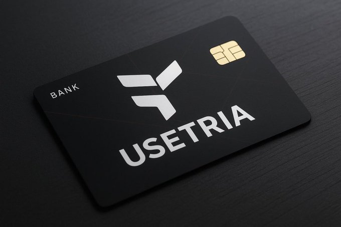 The image features a black credit card with white text that reads "useTria" and "Bank". The credit card has a gold stripe running down its center, indicating that it may be a Mastercard or Visa card. The card appears to have been used recently, as there is a small amount of writing on the back.