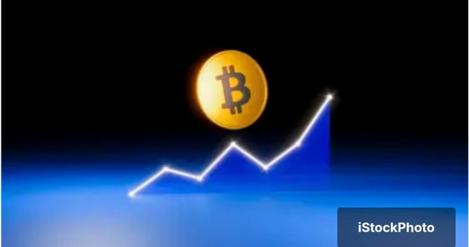 A graphic of a Bitcoin coin floats above an upward-trending line graph against a blue background, featuring the iStockPhoto logo in the corner.