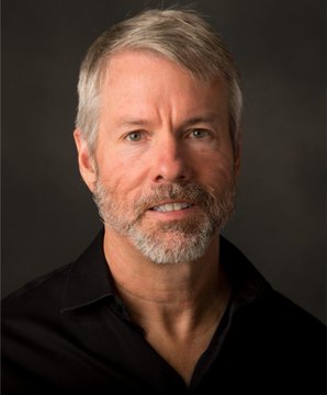 A professional headshot shows a middle-aged man with gray hair and a salt-and-pepper beard, wearing a black collared shirt, smiling slightly against a dark gray background. The image appears to be paired with a critical post mocking the subject's questionable statements about Bitcoin and personal credibility.