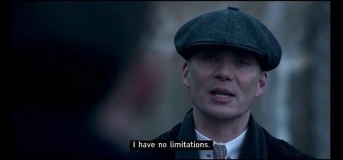 A close-up shot from a film shows a man wearing a flat cap and dark coat, with a subtitle reading 'I have no limitations.'