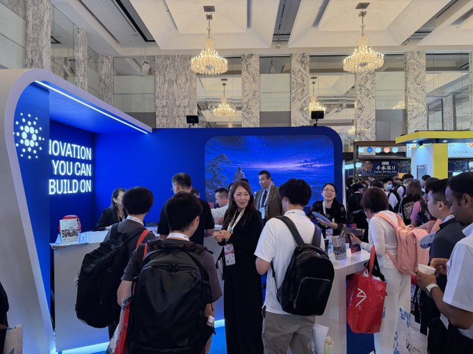 Attendees gather at the Cardano booth featuring signage reading "INNOVATION YOU CAN BUILD ON," showcasing the brand's presence at the WebX conference in Tokyo as part of a unified global marketing strategy.