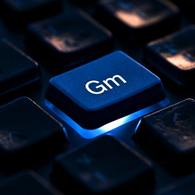 A close-up of an illuminated blue keyboard key labeled 'Gm' glowing on a dark backlit keyboard.