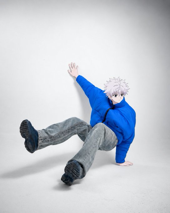 A young man in a blue sweatshirt and jeans is captured mid-fall or pose against a white background, with a cartoon anime head overlay featuring spiky pink hair.